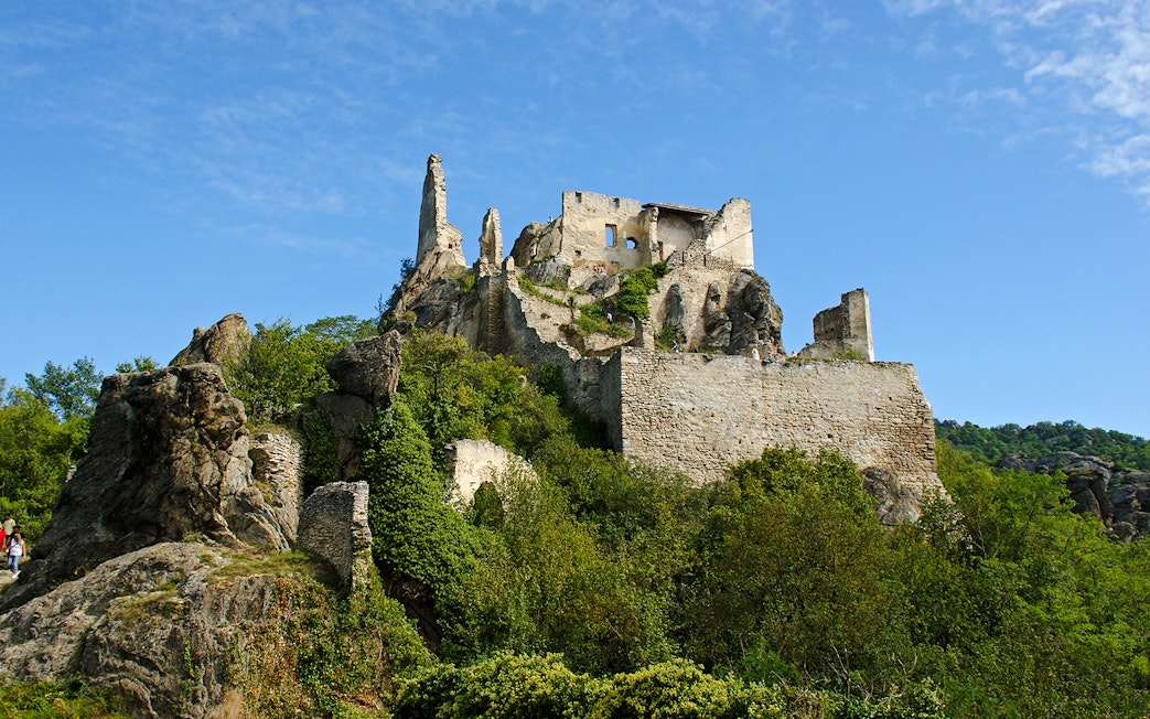 Dürnstein Castle ruins atop a rocky hill in Wachau Valley, surrounded by greenery.