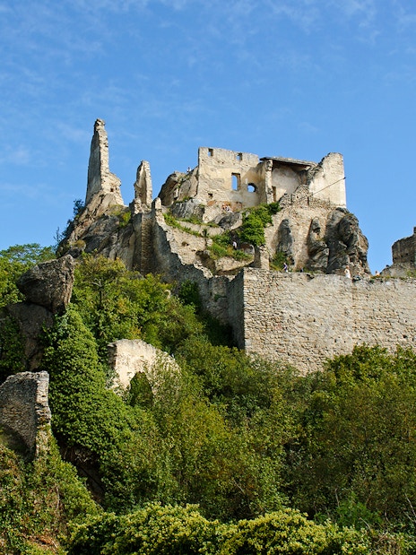 Dürnstein Castle ruins atop a rocky hill in Wachau Valley, surrounded by greenery.