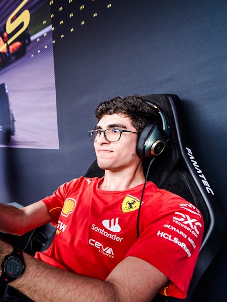 Person using a race simulator with a large screen and headphones.