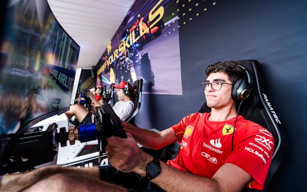 Person using a race simulator with a large screen and headphones.