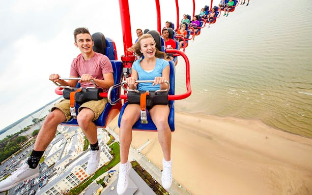 Riders enjoying WindSeeker ride at Cedar Point with a view of the beach below.
