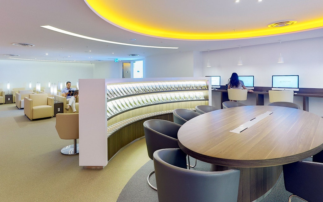 Plaza Premium Lounge seating area with computers and reading space in International Departures.