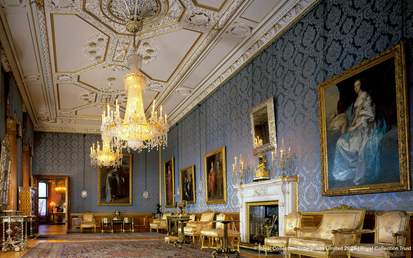 Windsor Castle interior with ornate chandeliers, blue damask walls, and classic paintings.