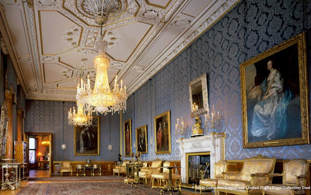 Windsor Castle interior with ornate chandeliers, blue damask walls, and classic paintings.