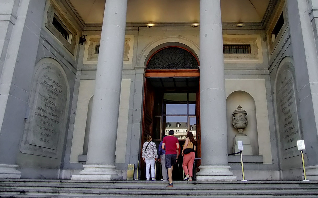 Visitors entering the Prado Museum in Madrid for a guided tour.