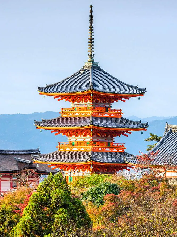 Kiyomizudera Temple pagoda surrounded by autumn foliage in Kyoto, Japan.