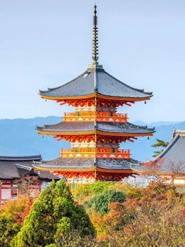 Kiyomizudera Temple pagoda surrounded by autumn foliage in Kyoto, Japan.