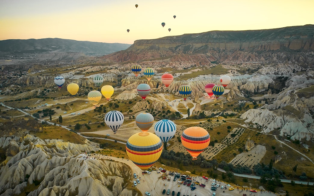 Hot air balloons over Cappadocia's unique rock formations at sunrise.