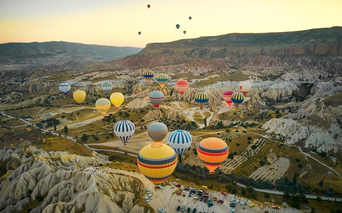 Hot air balloons over Cappadocia's unique rock formations at sunrise.