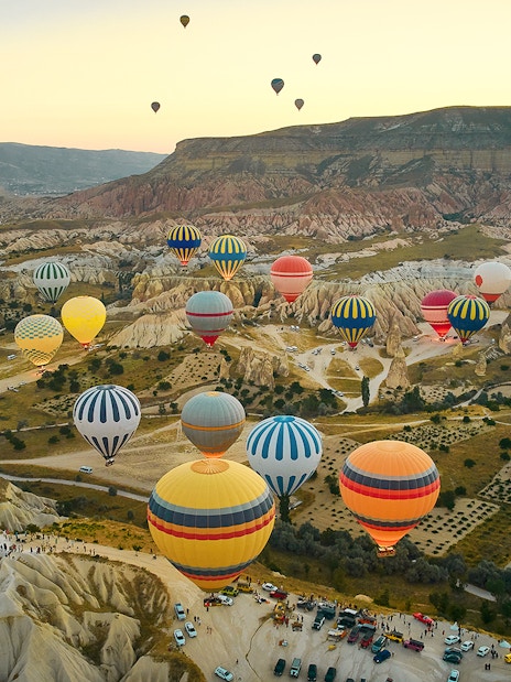 Hot air balloons over Cappadocia's unique rock formations at sunrise.