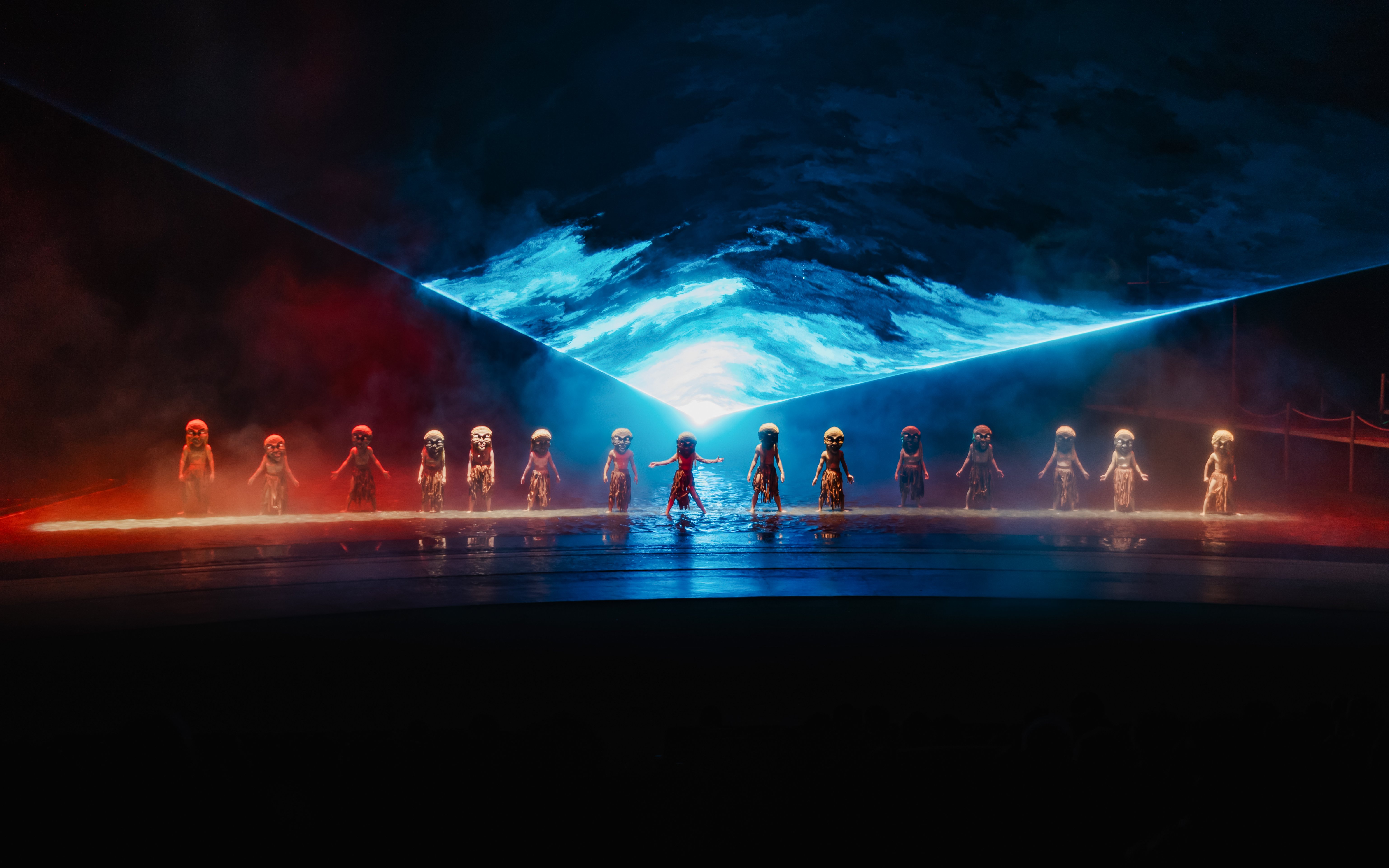 Performers in masks on stage with blue and red lighting at The Legacy of a Generation Show.