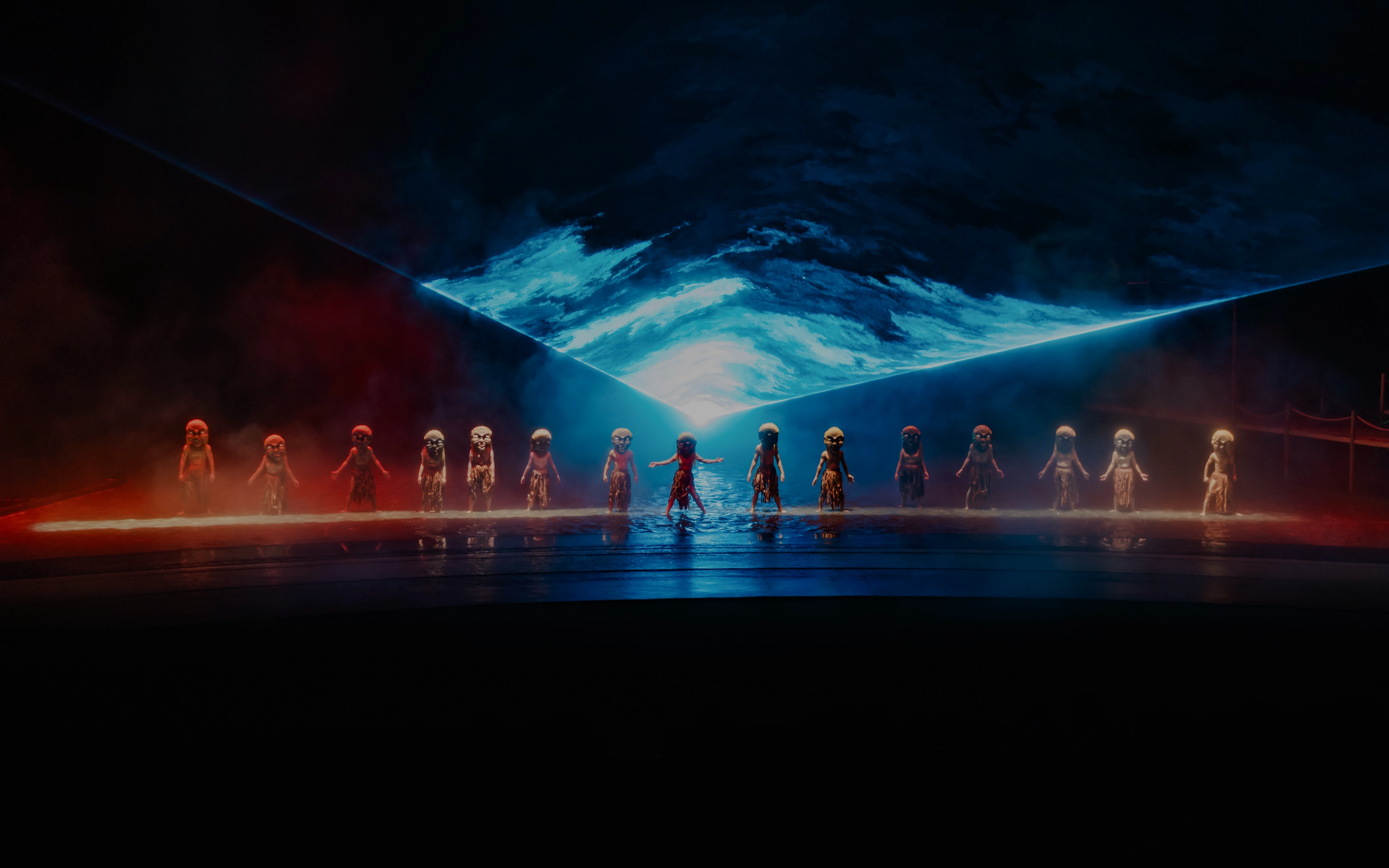 Performers in masks on stage with blue and red lighting at The Legacy of a Generation Show.