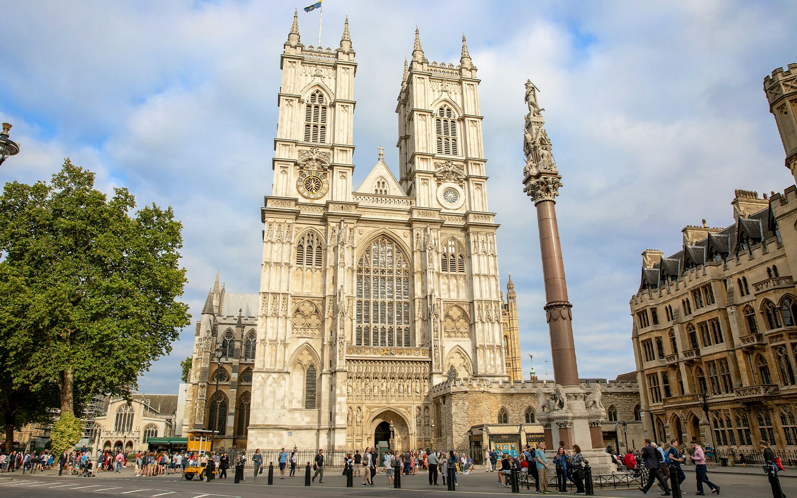 People gathered outside Westminster Abbey, London, admiring its Gothic architecture.