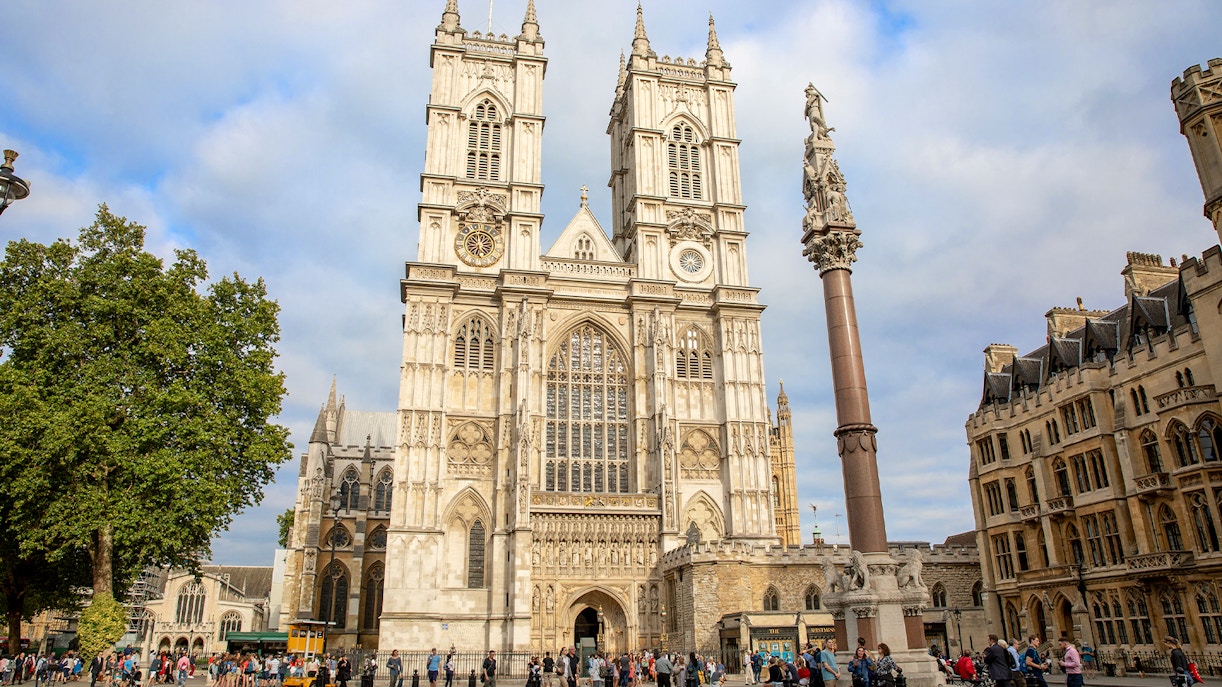 People gathered outside Westminster Abbey, London, admiring its Gothic architecture.