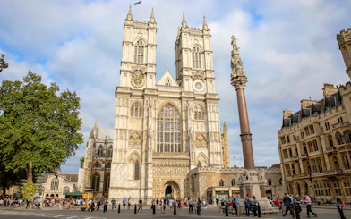People gathered outside Westminster Abbey, London, admiring its Gothic architecture.