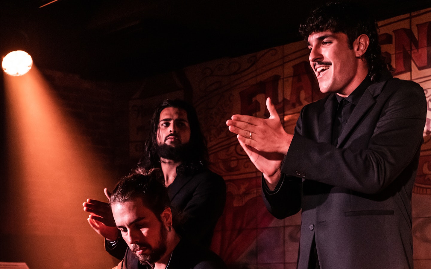 Flamenco performers clapping and singing at Flamenco De Leones Show.