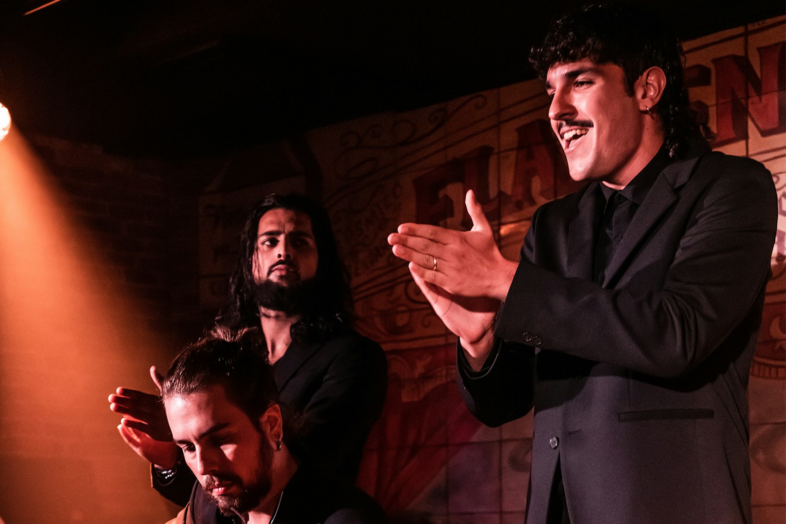 Flamenco performers clapping and singing at Flamenco De Leones Show.