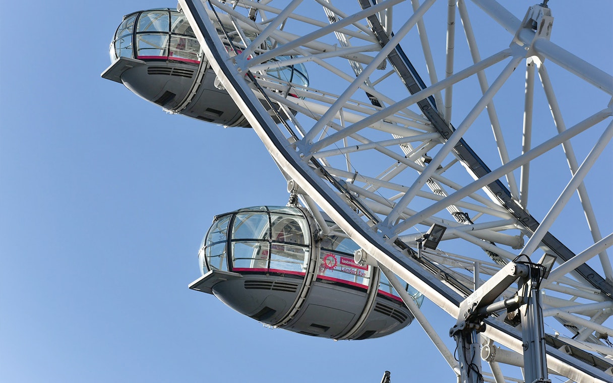 Ferris wheel capsules on the London Eye against a clear blue sky.