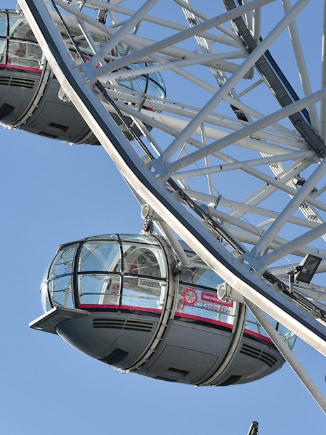 Ferris wheel capsules on the London Eye against a clear blue sky.