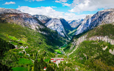 Aerial view of Flåm village nestled in a lush valley surrounded by mountains in Western Norway.