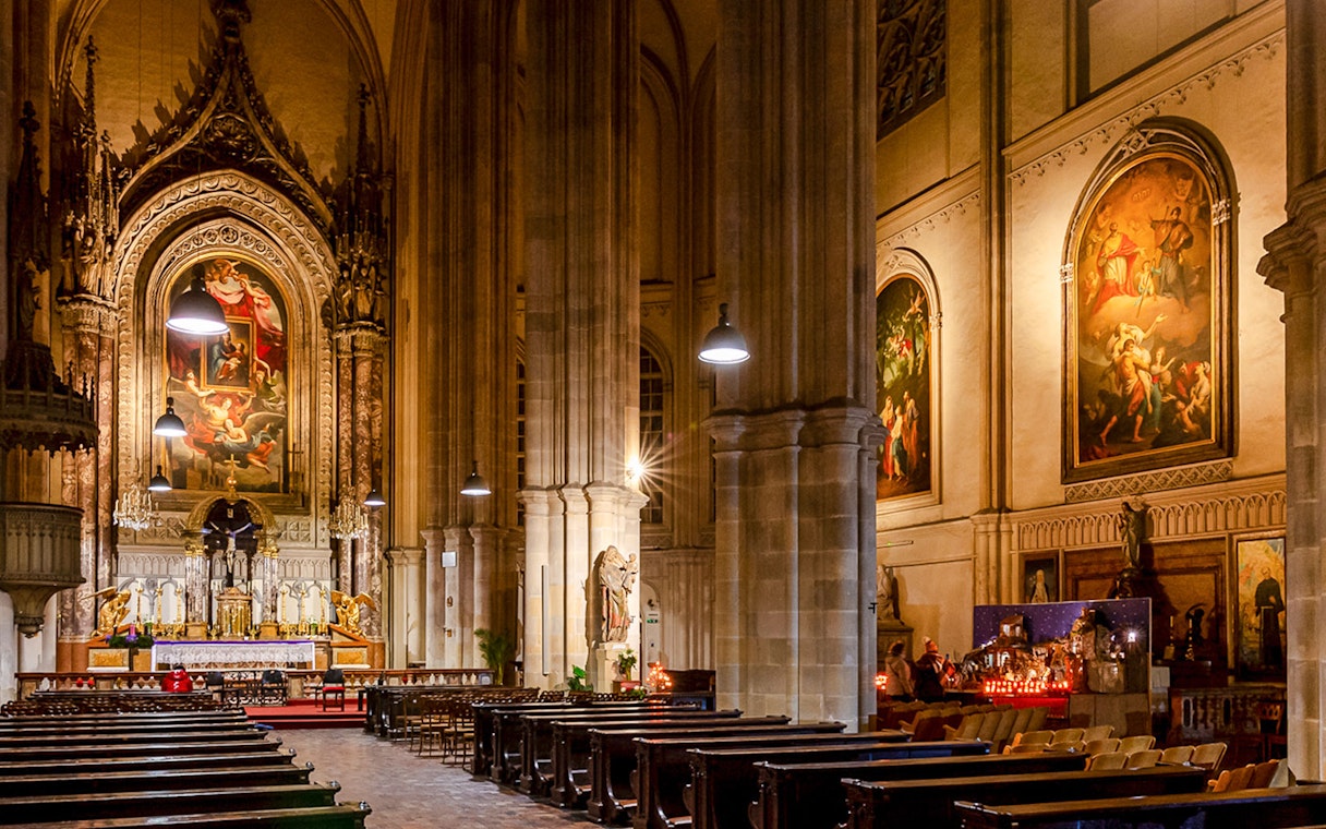 Interior of Minoritenkirche with ornate altar and classical paintings, Vienna concert venue.