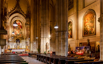 Interior of Minoritenkirche with ornate altar and classical paintings, Vienna concert venue.