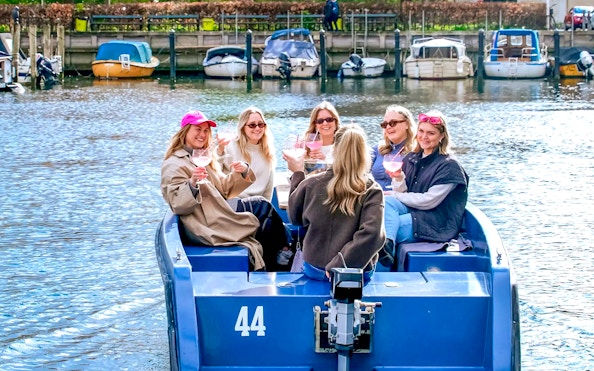 Guests enjoying a boat tour in Copenhagen harbor with colorful waterfront buildings.