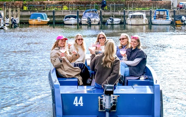 Guests enjoying a boat tour in Copenhagen harbor with colorful waterfront buildings.