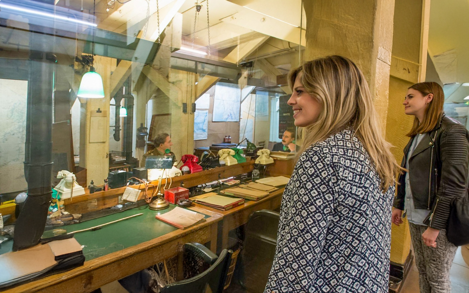 Guests observing the historic operations room inside the Churchill War Rooms, London.