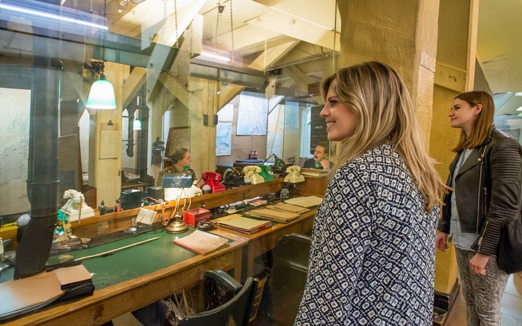 Guests observing the historic operations room inside the Churchill War Rooms, London.