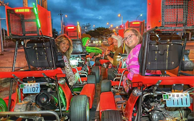 People in costumes driving go-karts on a street in Okinawa.