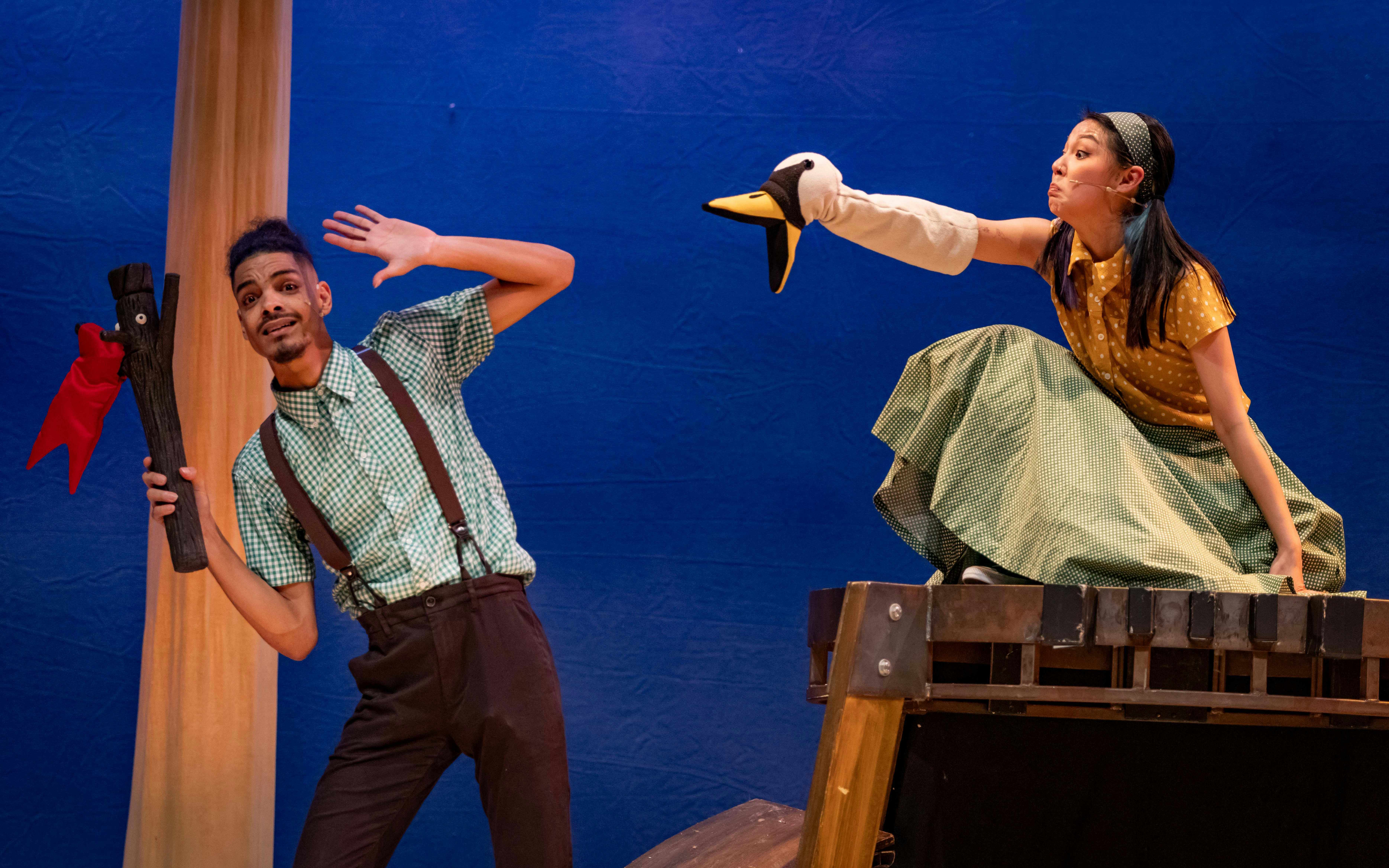 Actors performing Stick Man on West End stage with puppet interaction.