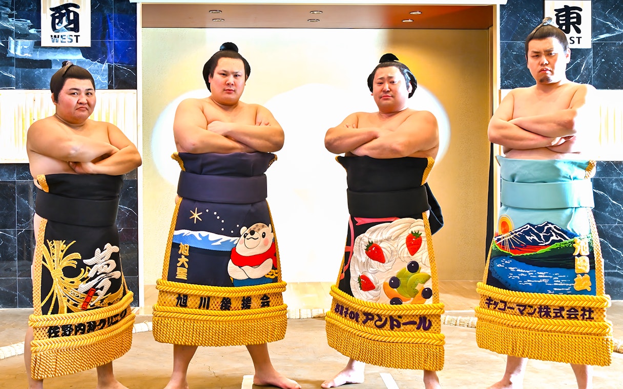 Sumo wrestlers posing at Asakusa Sumo Club, Tokyo.