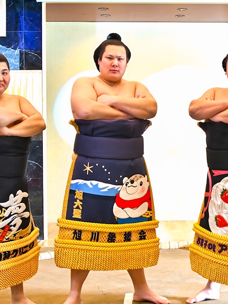 Sumo wrestlers posing at Asakusa Sumo Club, Tokyo.