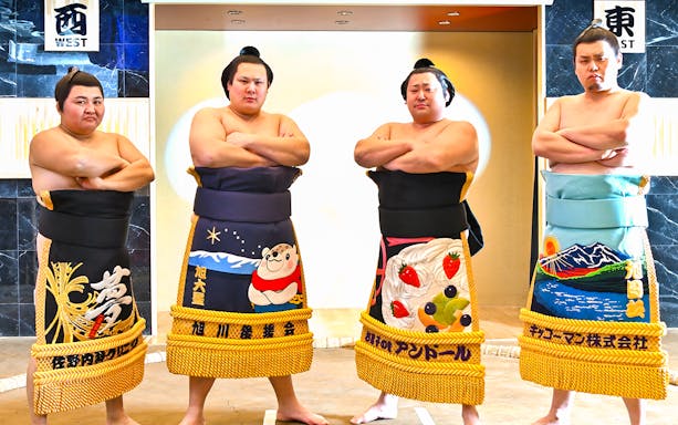 Sumo wrestlers posing at Asakusa Sumo Club, Tokyo.