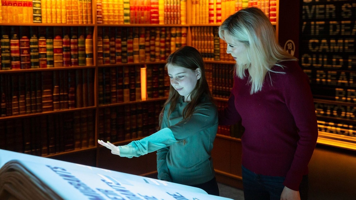 Visitors interacting with a digital display at an epic museum exhibit.