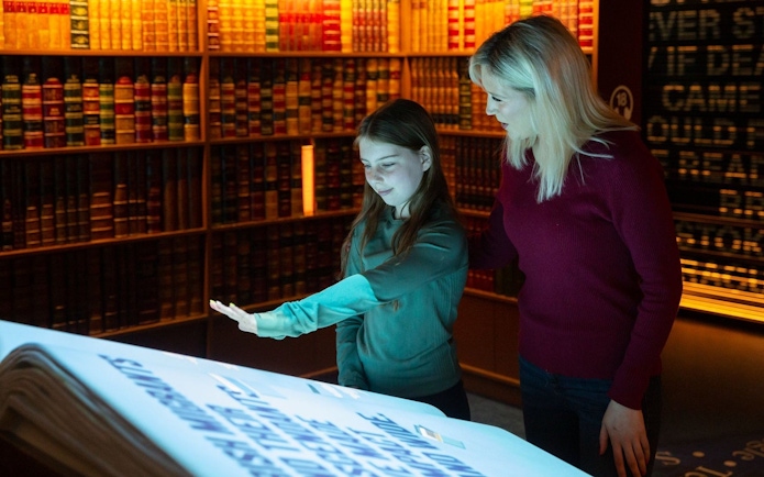 Visitors interacting with a digital display at an epic museum exhibit.