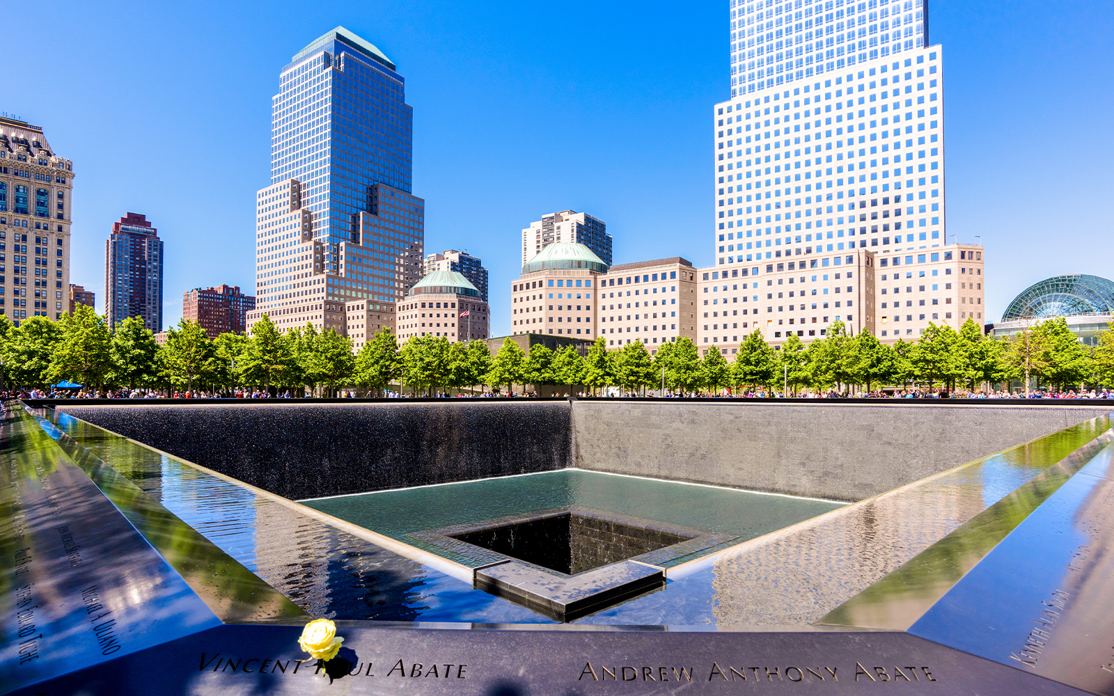 9/11 Museum exterior with glass facade and surrounding trees in New York City.