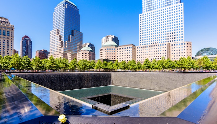 9/11 Museum exterior with glass facade and surrounding trees in New York City.