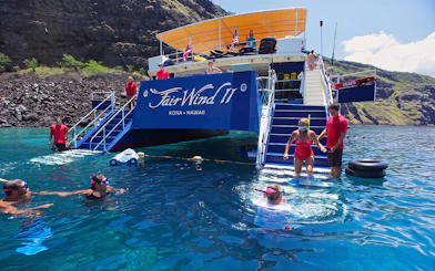 Snorkelers entering water from boat at Kealakekua Bay, Hawaii.