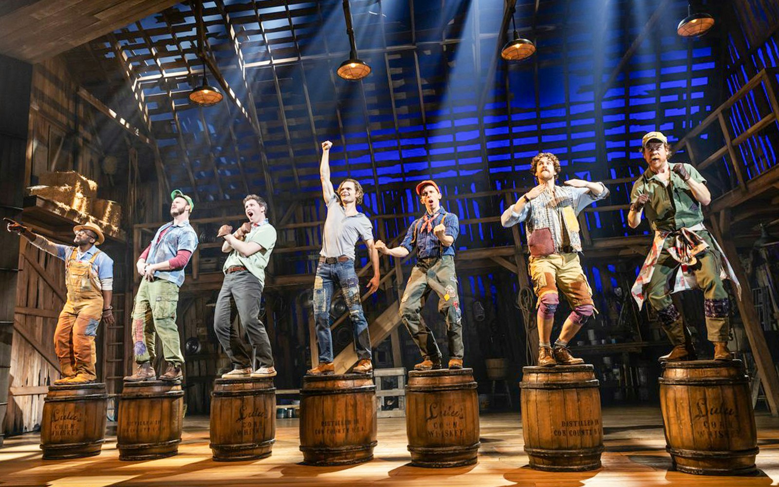 Performers on stage in a barn setting during the musical "Shucked.