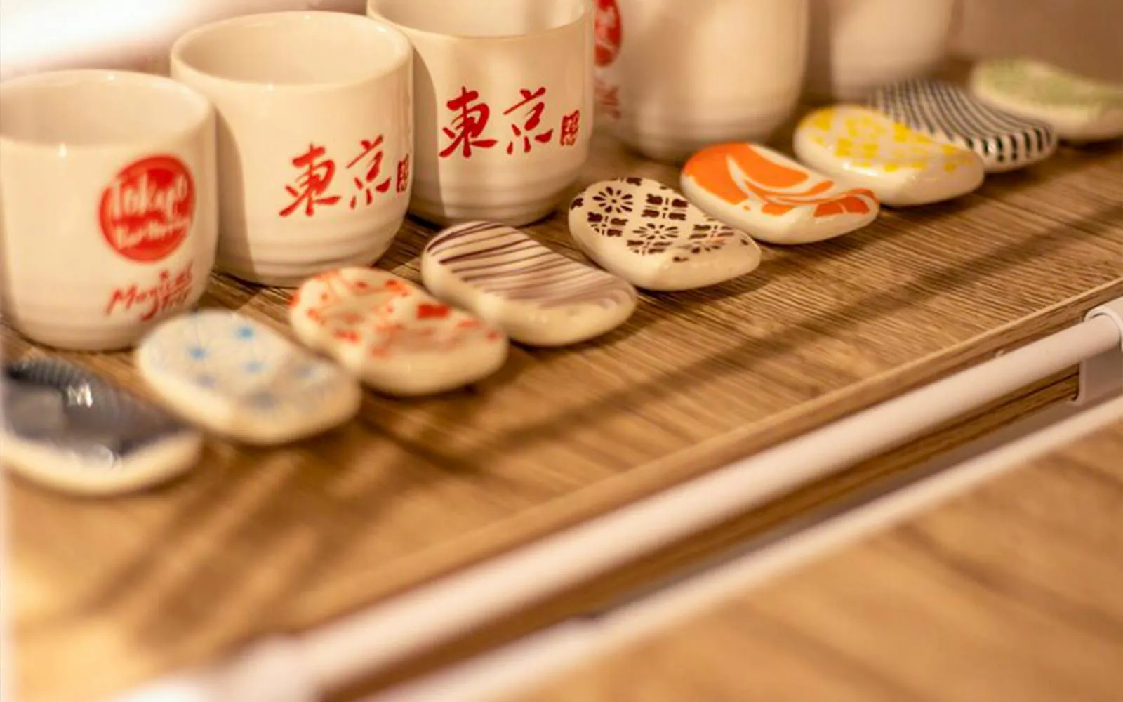 Ceramic sake cups and chopstick rests in a Tokyo izakaya cooking class setting.