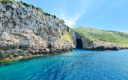 Haxhi Ali Cave entrance with clear blue water, Blue Caves Albania tour.