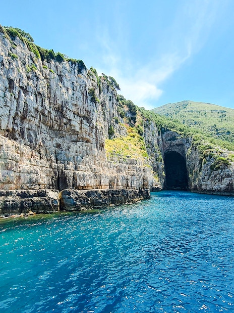 Haxhi Ali Cave entrance with clear blue water, Blue Caves Albania tour.