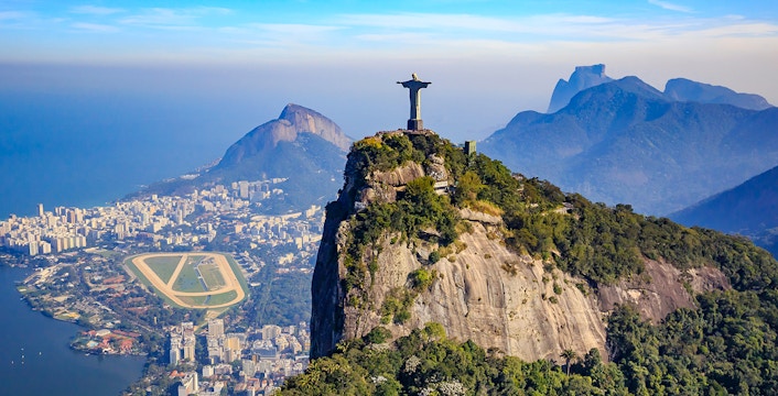 Christ the Redeemer statue overlooking Rio de Janeiro, Brazil, with cityscape and mountains.