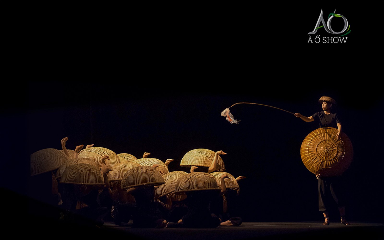 Performers with bamboo baskets in a traditional AO show scene.