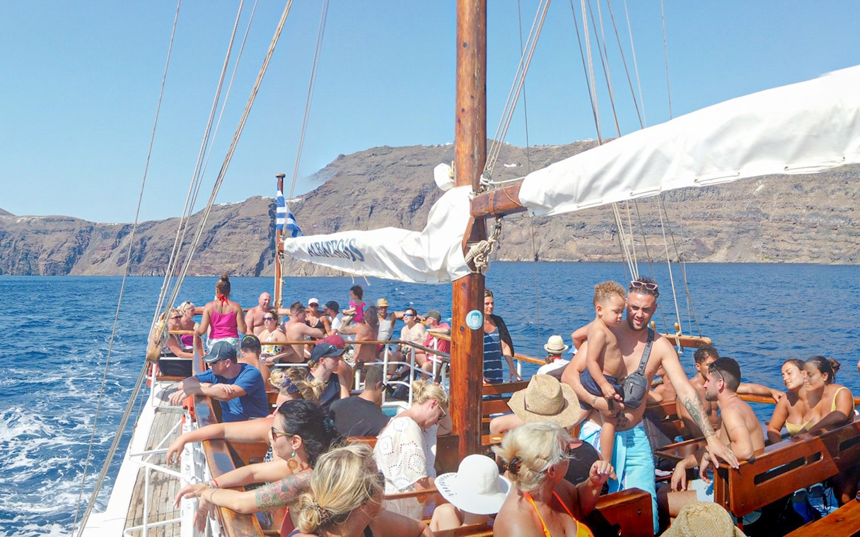 Guests on a boat enjoying Santorini Volcanic Islands cruise with scenic views.