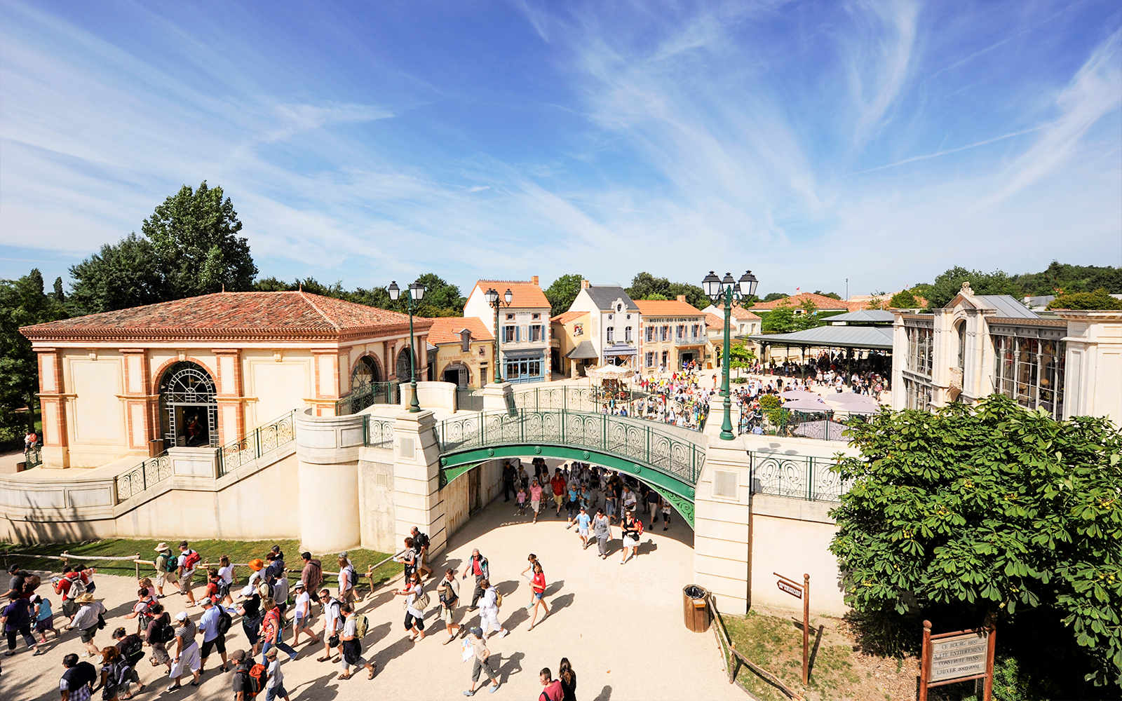 Visitors walking through Puy du Fou theme park entrance in France.