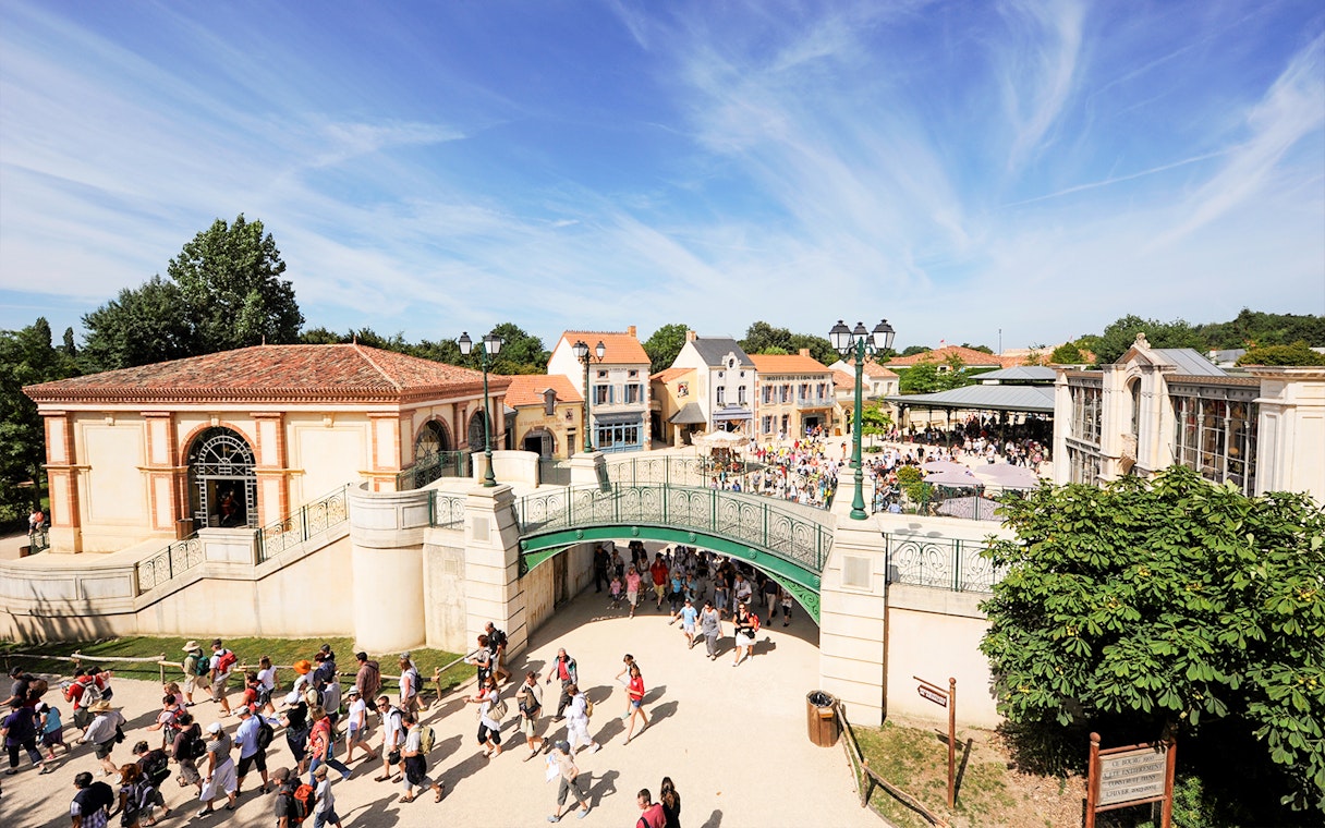 Visitors walking through Puy du Fou theme park entrance in France.