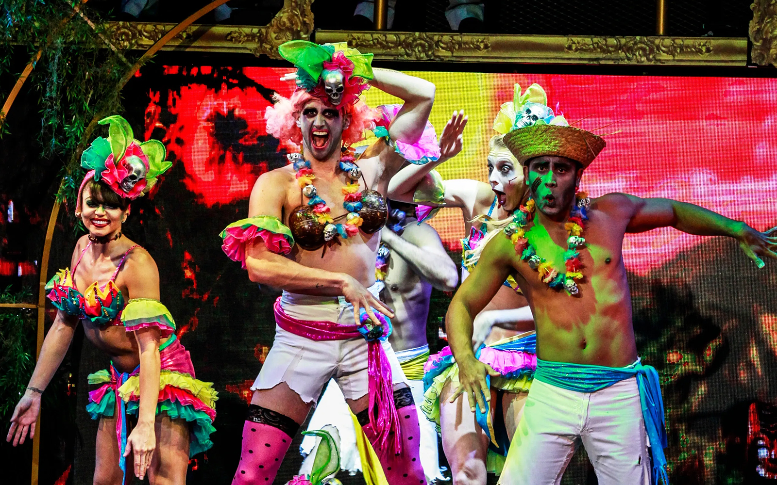 Performers in colorful costumes on stage during Zombie Burlesque show.
